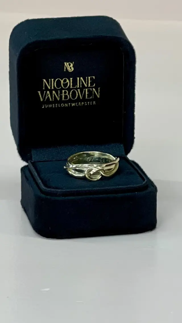 Sommige sieraden herinneren je aan iemand die je voor altijd in je hart draagt. 

Deze mevrouw verloor haar man en wilde van hun twee trouwringen een herinneringsring laten maken.

Het belangrijkste thema voor haar?
Verbinding.

Haar oog viel op een wikkeling uit mijn collectie met een knoopje: een symbool van verbondenheid, zonder begin of einde.

Maar er was één belangrijke wens: de gravering moest behouden blijven.

Dus zaagde ik beide trouwringen smaller, precies tot aan de gravering. Het restmateriaal, samen met een oude ring van haar, smolten we om en walsden we tot een lange strip.

Daaruit ontstond deze oneindige wikkel, verbonden met het kleine knoopje.

Een nieuw sieraad, waarin haar herinneringen samenkomen.

“Schitterend geworden,” zei ze.
“Ik heb het al aan iedereen laten zien.”

Dat ik van iets wat zo dierbaar is, iets mag maken dat opnieuw gedragen kan worden.
Dat vind ik ontzettend bijzonder.

#rouwjuweel #goudsmidzeeland #herinneringssieraad #wikkelring #juweelontwerpster