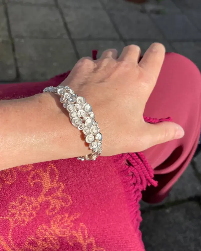 Een roosjes armband die gezien mag worden.

Soms kijk je zo lang naar je eigen ontwerpen dat je vergeet hoe bijzonder ze eigenlijk zijn.

Deze zilveren schakelarmband met gestileerde rozen had ik al een tijdje niet meer laten zien. Tot iemand er onlangs enthousiast op reageerde. Ineens keek ik er zelf ook weer met andere ogen naar.

Een uitgesproken statement piece, schakel voor schakel en roosje voor roosje opgebouwd. Een signatuurontwerp met een eigen karakter.

#zilverenarmband #statementjewellery #roosjessieraden #handgemaaktearmband #pieceunique